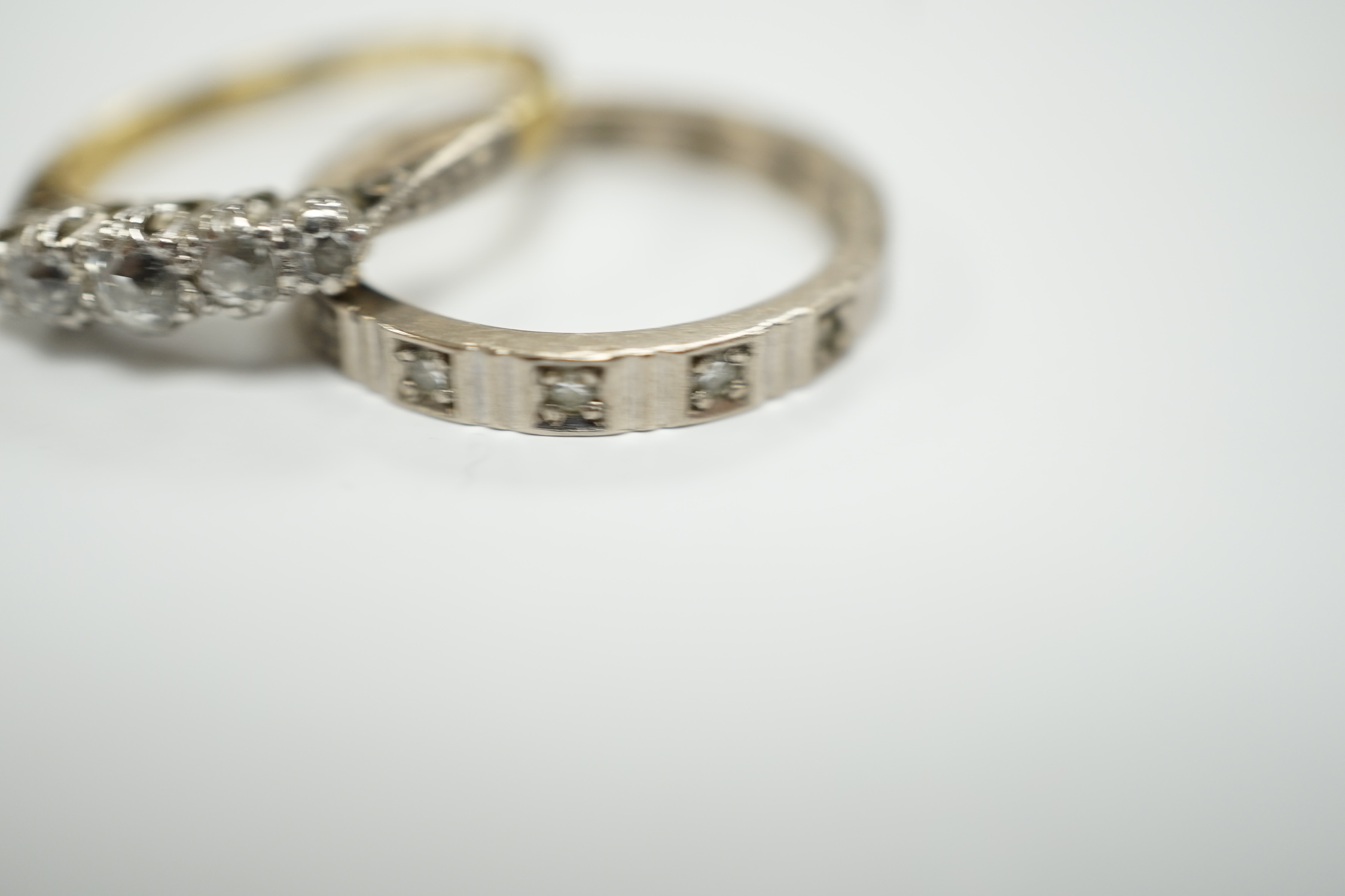 A 750 white metal and diamond chip set full eternity ring and an 18ct and graduated five stone diamond chip set ring, gross weight 6.6 grams.